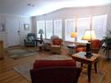 Bright living room featuring hardwood floors, white walls, and large windows with natural light at 554 Aspen Ave, Venice, FL 34285