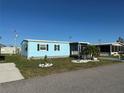Exterior view of a cozy blue house, complemented by a well-maintained lawn at 56 Lakeview Dr, North Port, FL 34287