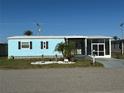 A beautiful blue house is enhanced by lush landscaping and a welcoming entrance at 56 Lakeview Dr, North Port, FL 34287