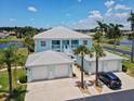 Bright blue two-story condo with white trim, three garage doors, and lush palm trees on a sunny day at 5739 Sabal Trace Dr # 102, North Port, FL 34287
