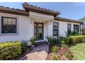 Charming front entrance with a brick walkway, decorative glass door, and manicured landscaping at 5853 Semolino St, Nokomis, FL 34275