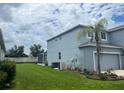 Side view of home featuring a screened-in porch, a garage, and a well-manicured backyard at 5966 Willows Bridge Loop, Ellenton, FL 34222