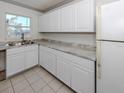 Well-lit kitchen offering white cabinets, marble-look countertops, and an updated stainless steel sink at 6231 Jordan St, North Port, FL 34287