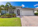 Charming home with well-maintained landscaping, a brick driveway, and a two-car garage at 629 Ibiza Loop, Venice, FL 34292