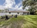 Spacious backyard featuring a fire pit, Adirondack chairs, dining area, and privacy fence at 6497 Honeycomb Cir, North Port, FL 34291