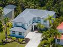 Aerial view showcasing a two-story home with a gray tile roof, complemented by lush landscaping and a spacious driveway at 678 Clear Creek Dr, Osprey, FL 34229