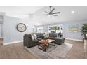 Cozy living room featuring a large sectional sofa, neutral colors, and wood-look tile flooring at 755 Mohawk Rd, Venice, FL 34293