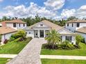 Beautiful gray home with a tile roof, elegant columns, and lush landscaping at 9048 Luna Ln, Sarasota, FL 34241