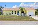 Lovely yellow home with attached garage, appealing landscaping, and a sunny curb appeal at 10444 Willmington Blvd, Englewood, FL 34224