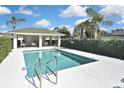 Community pool area featuring a sparkling swimming pool with lounge seating and lush landscaping at 1104 Auburn Cove Cir, Venice, FL 34292