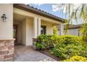 Inviting front porch area featuring stone accents and lush landscaping around the entrance at 12370 Canavese Ln, Venice, FL 34293