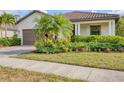 Well-manicured front yard with lush landscaping surrounding a charming single-story home at 12370 Canavese Ln, Venice, FL 34293