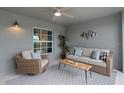 Relaxing covered patio features cozy seating, stylish decor, and a ceiling fan for ultimate comfort at 12440 Wellen Golf St # 204, Venice, FL 34293