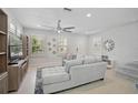 Inviting living room with tile flooring, plantation shutters, ceiling fan and open layout at 12689 Sagewood Dr, Venice, FL 34293