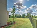 Spacious backyard featuring healthy green grass, black metal fence, and well placed landscaping at 12705 Pinnacle Ln, Venice, FL 34293