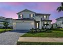 Beautiful two-story home featuring manicured lawn, brick driveway, and a two car garage at 12705 Pinnacle Ln, Venice, FL 34293