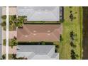 Overhead view of the brown roof, green grass, and adjacent bodies of water at 13486 Nobilio St, Venice, FL 34293
