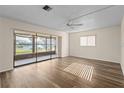 Bright living room featuring wood-look floors, a ceiling fan, and sliding glass doors to a lanai at 1728 S Lakeside Dr # 1720B, Venice, FL 34293