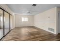 Bright living room featuring wood-look floors, a ceiling fan, and sliding glass doors to a lanai at 1728 S Lakeside Dr # 1720B, Venice, FL 34293