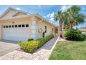 Well-maintained home featuring a two-car garage, brick walkway, and tropical landscaping at 1799 Fountain View Cir, Venice, FL 34292