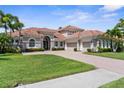 Beautiful home featuring a well-kept lawn, symmetrical landscaping, and a three-car garage for ample parking at 186 Portofino Dr, Nokomis, FL 34275