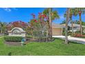 Community entrance sign surrounded by vibrant landscaping and mature trees at 201 Vestavia Dr, Venice, FL 34292