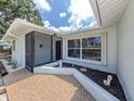 Close up of front entrance featuring welcome mat, window, and landscaping at 2020 E Crest Dr, Englewood, FL 34223