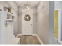 Bright foyer featuring hardwood floors, a decorative wreath, and a hall tree with coat hooks at 2034 Mesic Hammock Way, Venice, FL 34292