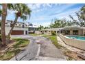 Exterior showcasing a well-maintained home, a pool, a spacious driveway, and lush landscaping, inviting and perfect for outdoor enjoyment at 205 Louella Ln, Nokomis, FL 34275