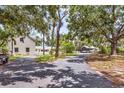 Exterior home view with a long driveway, mature trees offering shade, and ample parking, set in a tranquil environment at 205 Louella Ln, Nokomis, FL 34275
