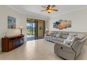 Bright and airy living room with tile flooring, a leather couch set and a sliding door that leads to the porch at 2104 Batello Dr, Venice, FL 34292