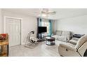 Cozy living room with tile floors, ceiling fan, natural light, and comfortable seating perfect for relaxation at 219 Capatola St, Port Charlotte, FL 33948