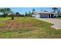 Spacious home featuring a two-car garage, a paved driveway, and a sizable front yard at 2194 Abalom St, Punta Gorda, FL 33980
