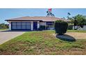 Charming single-story home with a two-car garage, a well-kept lawn, and attractive landscaping at 2194 Abalom St, Punta Gorda, FL 33980
