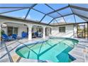 Inviting screened-in pool area with stone tile deck, poolside seating, and covered lanai at 269 Mark Twain Ln, Rotonda West, FL 33947
