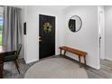 Inviting entryway with a dark front door, wood bench, round rug, and neutral wall color at 27215 Crosby Rd, Myakka City, FL 34251