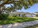 Beautiful one-story home with lush green lawn, mature tree, and well-maintained landscaping at 304 Rosewood Ct, Venice, FL 34293