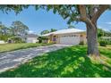 This charming one-story home features a well-manicured lawn, long driveway, and a durable metal roof at 331 Bucknell Rd, Venice, FL 34293