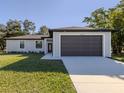 Beautiful single-Gathering home with two-car garage and well-kept lawn on a sunny day at 3588 Erie Ct, North Port, FL 34287