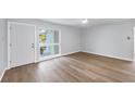 Bright, open-concept living area featuring hardwood floors, a modern ceiling fan, and a sunlit window with front yard views at 3616 Lalani Blvd, Sarasota, FL 34232
