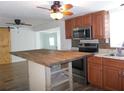 Modern kitchen featuring wood cabinets, stainless steel appliances, and stylish island counter at 373 Longwood Dr, Venice, FL 34285