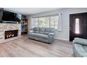 Relaxing living room featuring a stone fireplace, modern seating, and laminate floors at 413 Valencia Rd, Venice, FL 34285