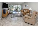 Inviting living room featuring tile flooring, a leather sofa, recliner, and access to the outdoor space at 418 Cerromar Ct # 158, Venice, FL 34293