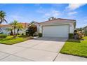 Single-story home boasts a two-car garage, well-maintained lawn, and beautiful landscaping at 4378 Summertree Rd, Venice, FL 34293