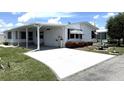 Inviting single-story home with a carport, well-kept white siding, and colorful flowerbeds in the front yard at 453 Sharks Pt, North Port, FL 34287