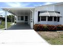 Well-maintained single-story home featuring a convenient carport, white siding, and beautiful landscaping at 453 Sharks Pt, North Port, FL 34287