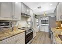 Bright kitchen featuring granite countertops, stainless steel appliances, and white cabinetry at 4646 Longwater Chase # 98, Sarasota, FL 34235