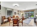 Inviting living room and dining area with wood floors and sliding door access to the lanai at 4646 Longwater Chase # 98, Sarasota, FL 34235