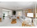 Spacious living room with ample natural light, plush sofas, and decorative furnishings with carpet flooring at 491 Cervina Dr, Venice, FL 34285