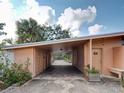 Covered carport with brick-paved parking and storage areas, framed by flowering plants at 602 Bonito Ave, Nokomis, FL 34275